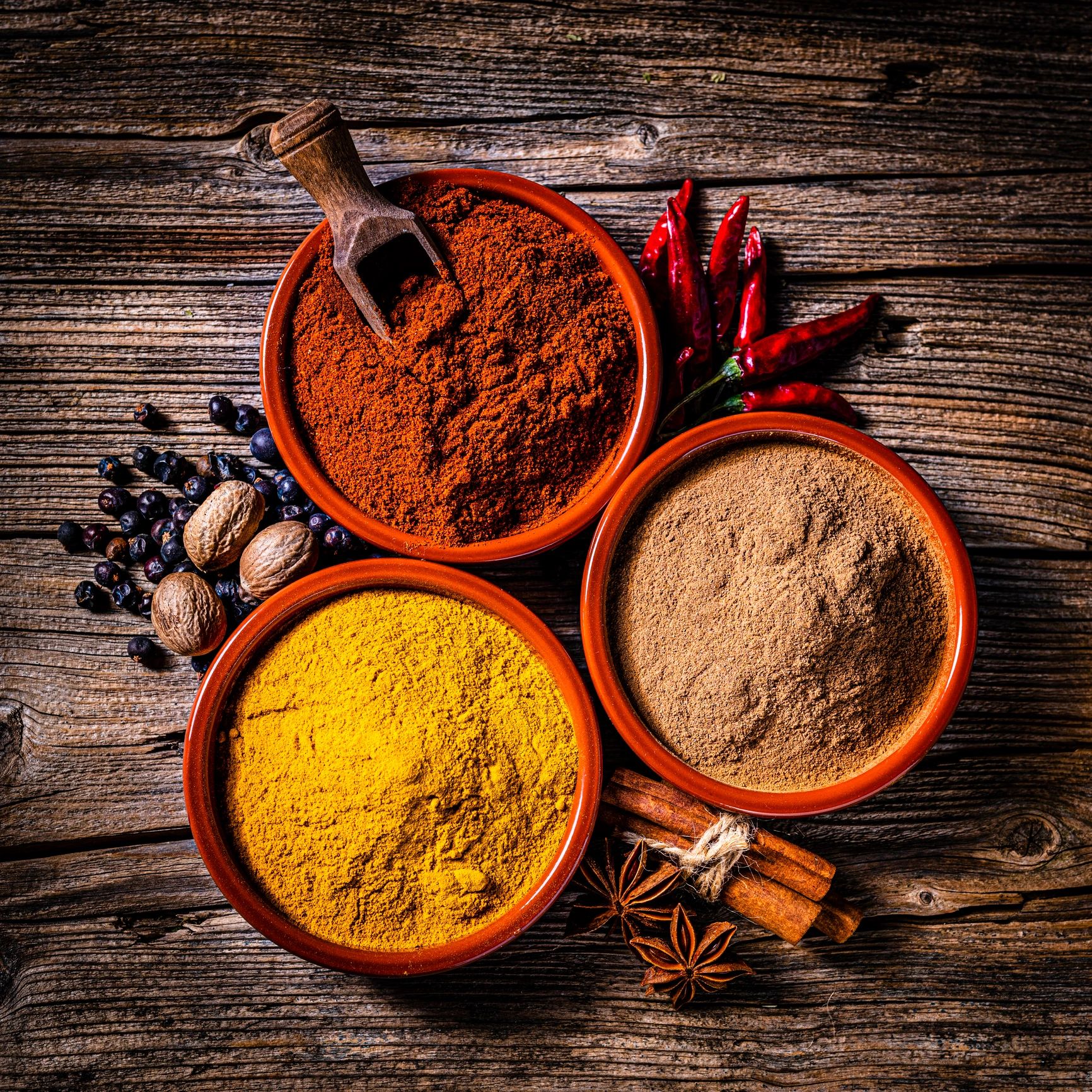 Bowls of turmeric, chili powder, and dried herbs